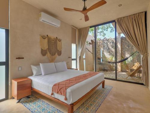 a bedroom with a bed and a large window at suite tropical en oasis tropical del centro de Mérida in Mérida
