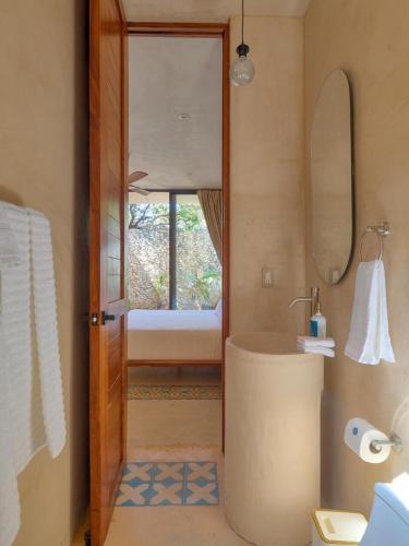 a bathroom with a tub and a sink and a bedroom at suite tropical en oasis tropical del centro de Mérida in Mérida