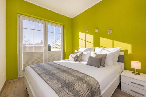 a bedroom with a large bed with green walls at Fewo Kleine Auszeit 02 in Koserow