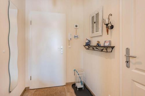 a hallway with a white door and a shelf at Fewo Kleine Auszeit 02 in Koserow