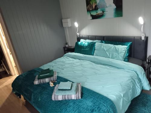 a bedroom with a bed with a blue comforter at Independent Garden Guesthouse, Private entrance, Sleep up to 4, Driveway Parking, Wi-Fi, Derby City in Derby