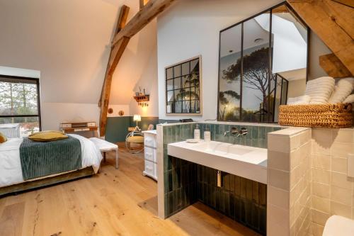 a bathroom with a sink and a bed in a room at Les Granges de Juvardeil in Juvardeil