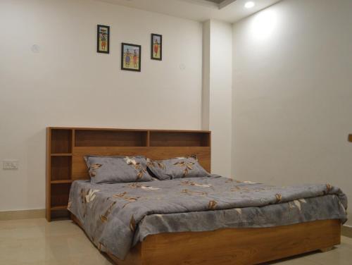 a bedroom with a large bed with a wooden headboard at Ananta 1BHK in Birbhaddar