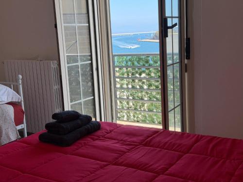 a bedroom with a red bed with a large window at L'atmosfera in Brindisi