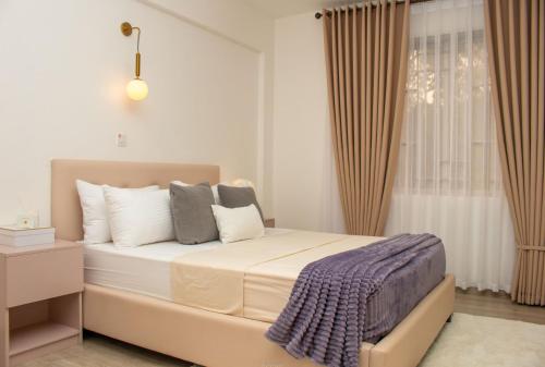 a bedroom with a large bed and a window at Rupa villas in Eldoret