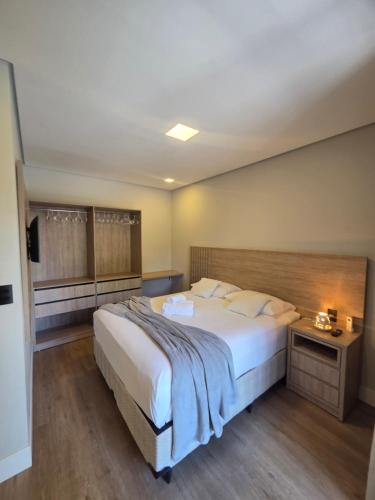 a bedroom with a large bed with a wooden headboard at Casa Luar de Pitinga in Arraial d'Ajuda