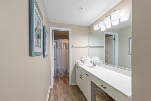 a bathroom with a sink and a large mirror at Phoenix X Unit 1512 in Orange Beach