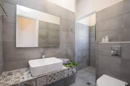 a bathroom with a sink and a toilet at Villa Lourdas Beach by Villa Plus in Trápeza