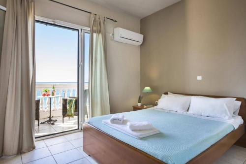 a bedroom with a bed and a large window at Villa Lourdas Beach by Villa Plus in Trápeza