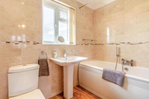 a bathroom with a toilet and a sink and a bath tub at 3 Bed in Walcott oc-2135 in Walcott