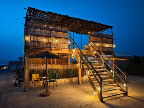 a building with stairs and a table and chairs at The Mogador's Oasis in Akermoud