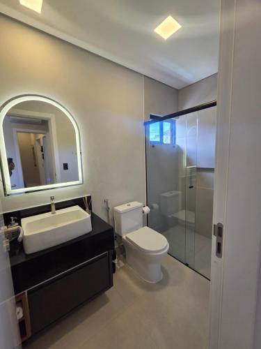 a bathroom with a toilet and a sink and a mirror at Casa Luar de Pitinga in Arraial d'Ajuda