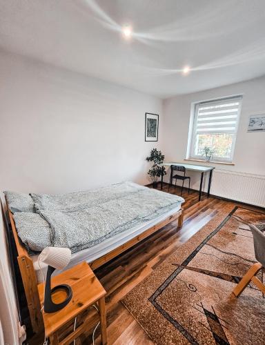 a bedroom with a bed and a table in it at Apartament 5 minut od Parku Zamkowego in Pszczyna