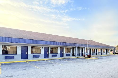 a building with blue doors in a parking lot at OYO Hotel Williamston in Williamston