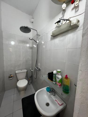 Un baño blanco con lavabo e inodoro. en Chambre studio, en Dakar