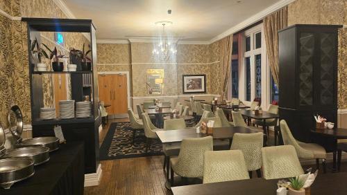 a restaurant with tables and chairs in a room at Mercure Darlington King's Hotel in Darlington