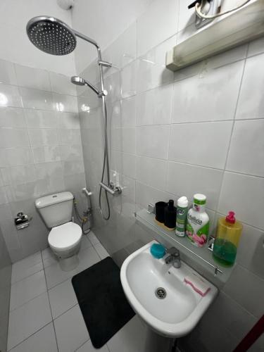 une salle de bains blanche avec un lavabo et des toilettes dans l'établissement Chambre studio, à Dakar