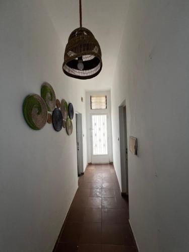 un pasillo con sombreros en la pared y una lámpara de techo en Chambre studio, en Dakar