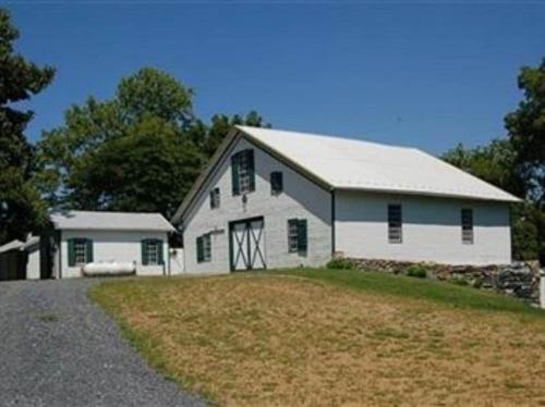 a white barn with a gambrel roof at Stocks Manor Bed and Breakfast in Mechanicsburg