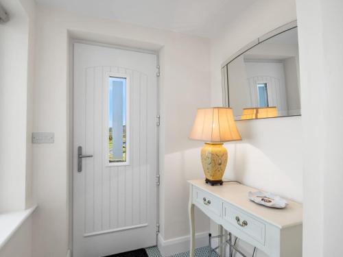 a white room with a table with a lamp and a mirror at 3 Bed in Cashel oc-a32863 in Glinsk