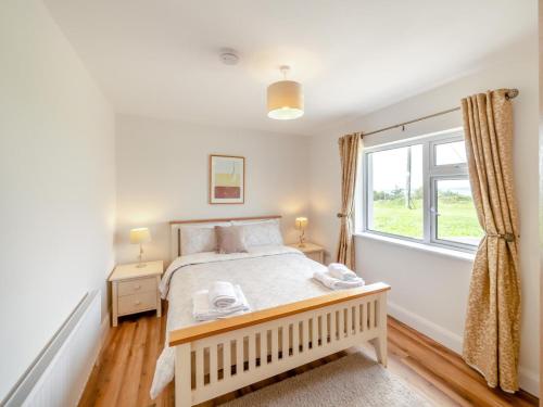 a bedroom with a bed and a window at 3 Bed in Cashel oc-a32863 in Glinsk