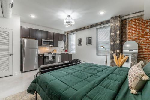 a bedroom with a green bed and a kitchen at Park Hotel Studio Suite 411 in Chattanooga