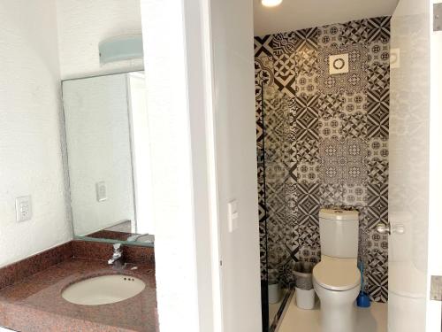 a bathroom with a toilet and a sink and a mirror at Divine Suite Cancun - BEACH CONDO - 6PX in Cancún