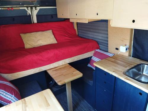 a small room with a bed and a sink at Kampervan in Vrhovine
