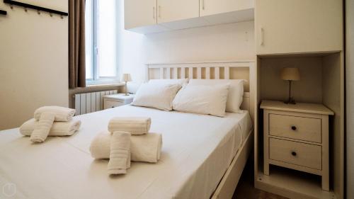 a bedroom with a white bed with towels on it at XX Settembre 68 in Alassio
