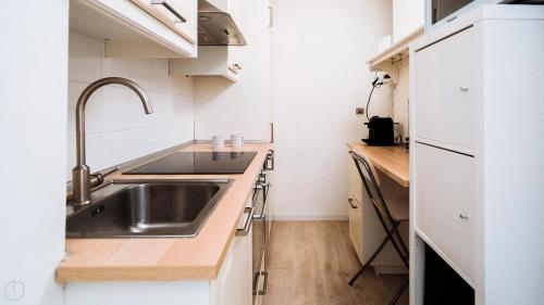 a kitchen with white cabinets and a sink at XX Settembre 68 in Alassio
