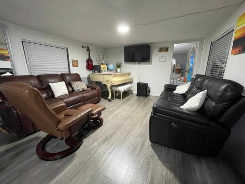 a living room with leather furniture and a piano at Tiny but cozy manufactured house in Tampa