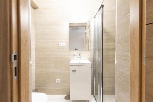 a bathroom with a sink and a shower at Trajadinha do Lima Rooms in Ponte de Lima