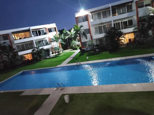 a swimming pool in front of a building at night at Departamento en renta vacacional nuevo Vallarta puerta del valle Valle dorado in Nuevo Vallarta