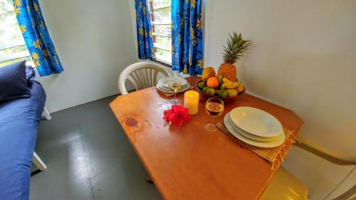 a wooden table with a bowl of fruit on it at Matriki Beach Huts in Arutanga