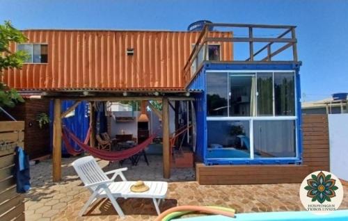 a house with a swing and a hammock in front of it at Hospedagem Tribos Livres in Torres