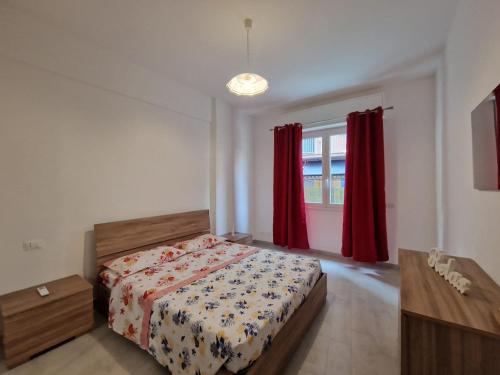 a bedroom with a bed and a window with red curtains at Appartamento Denis in Rapallo