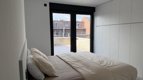 a bedroom with a bed and a large window at The 996 Business Flat in Lommel