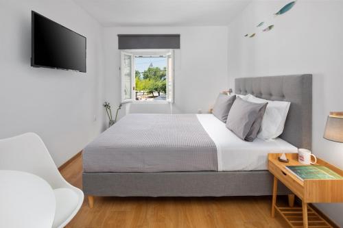 una camera da letto con un letto, una televisione e un tavolo di Old Port Breeze a Corfu