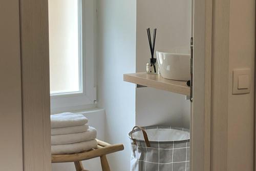 un bagno con una pila di asciugamani su uno scaffale di Old Port Breeze a Corfu
