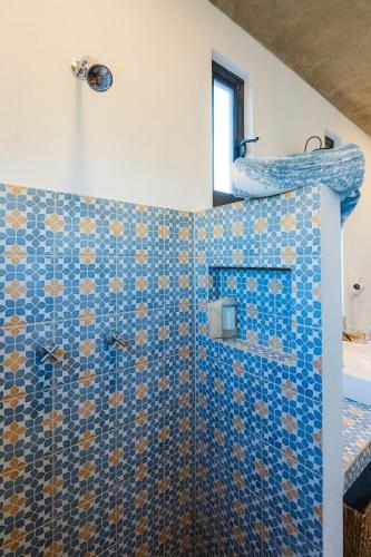 a bathroom with a shower with a blue tiled wall at Ola in San Carlos
