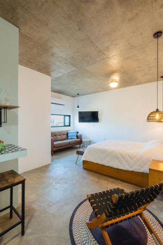 a bedroom with a large bed and a couch at Ola in San Carlos