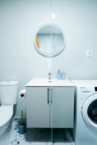 a bathroom with a sink and a toilet and a mirror at Apartament centru in Râmnicu Vâlcea