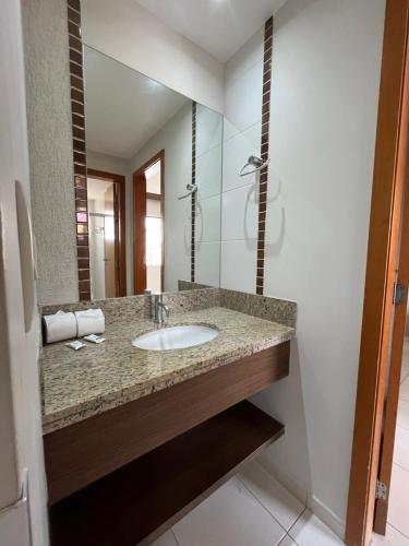 a bathroom with a sink and a mirror at Privê Boulevard Suíte Hotel - 706 - Caldas Novas GO in Caldas Novas