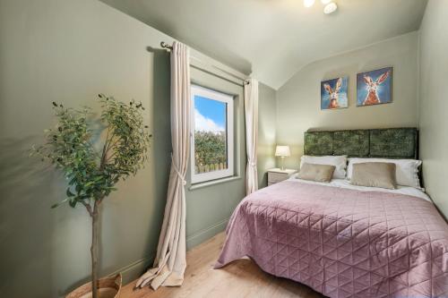 a bedroom with a purple bed and a window at The Meadows at Marlhill in Tipperary