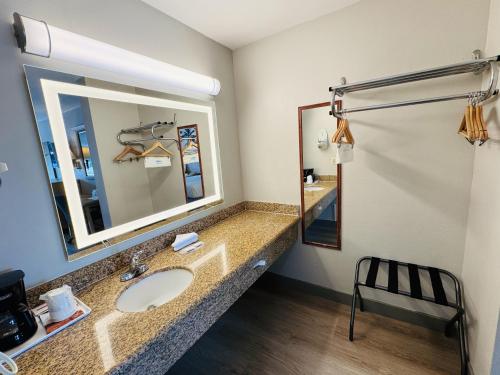 a bathroom with a sink and a mirror at Days Inn by Wyndham Anaheim Near the Park in Anaheim