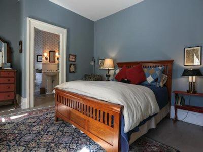 a bedroom with a large bed with blue walls at Black Sheep Inn in Hammondsport