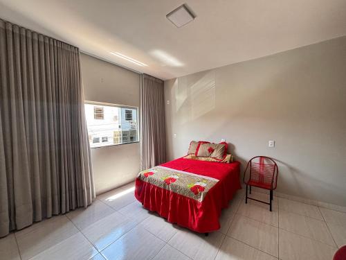 a bedroom with a red bed and a window at Apartamento tecnoshow in Rio Verde
