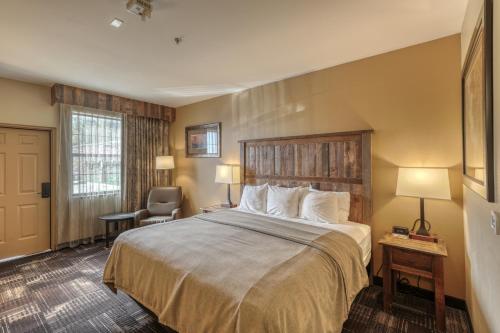 a hotel room with a bed and a chair at The Lodge at Deadwood in Deadwood