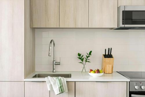 a kitchen with a sink and a bowl of fruit at The Cove Hotel in Montréal