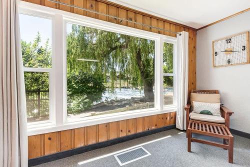 a room with a large window and a chair at Ground Floor River Front Studio Cottage in Bend